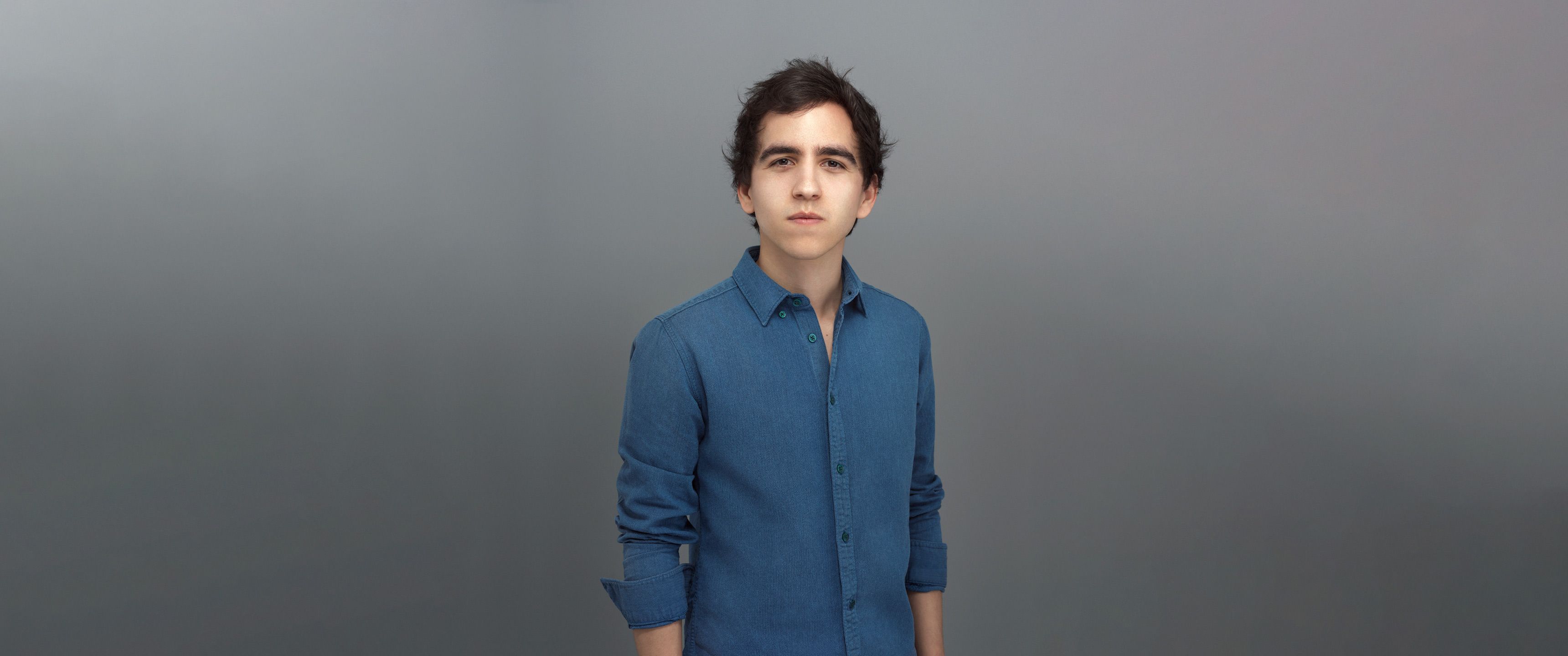 Decent portrait of Youen wearing a textured blue shirt